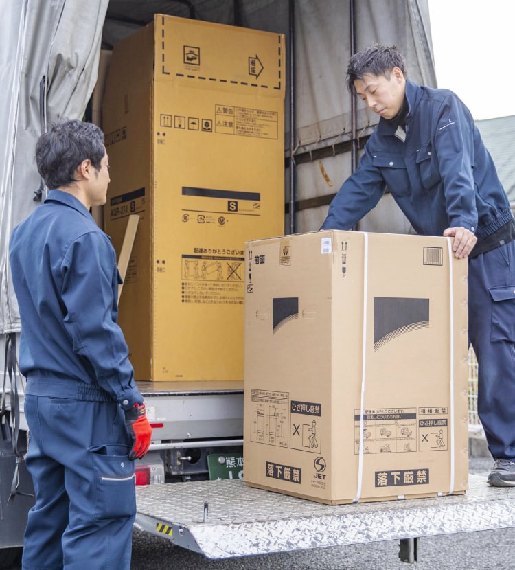 トラックから大型家電を運ぶスタッフ